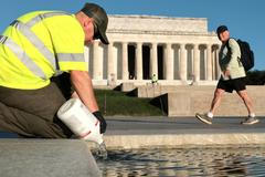 U.S. National Park Service workers dump bottles of hydrogen peroxide in the Lincoln Memorial Reflecting Pool in Washington