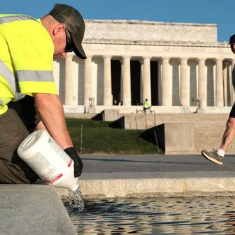 U.S. National Park Service workers dump bottles of hydrogen peroxide in the Lincoln Memorial Reflecting Pool in Washington