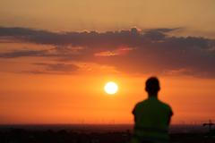 A man watches the rising sun in Berlin