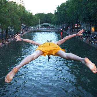 A man dives into the water in the Canal Saint-Martin in Paris