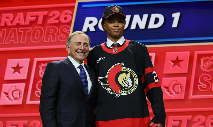 Dvaatřicátý hráč draftu NHL 2026 Jaxon Cover v dresu Ottawy pózuje vedle šéfa ligy Garyho Bettmana.