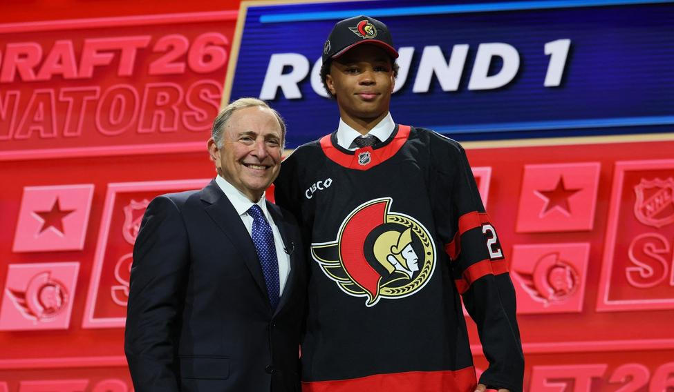 Dvaatřicátý hráč draftu NHL 2026 Jaxon Cover v dresu Ottawy pózuje vedle šéfa ligy Garyho Bettmana.