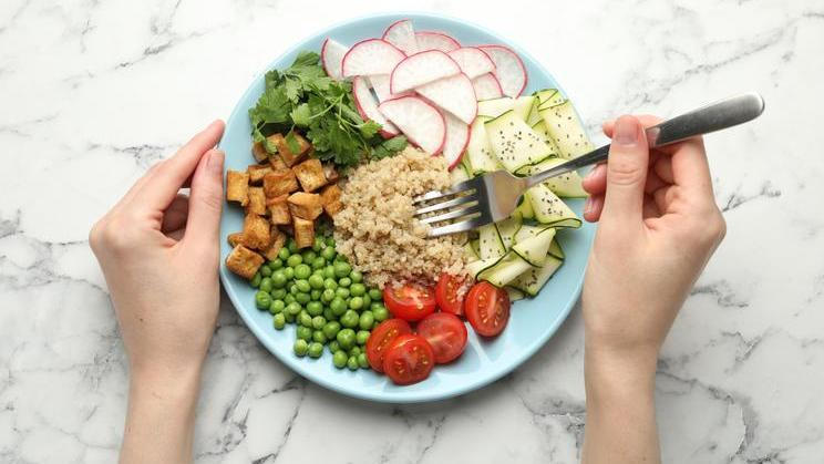 Woman,Eating,Different,Healthy,Vegetarian,Food,At,White,Marble,Table,