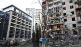 Residents look at damaged buildings following overnight Russian missile and drone strikes, in Kyiv