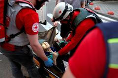Medical workers evacuate an elderly woman following overnight Russian missile and drone strikes, in Kyiv