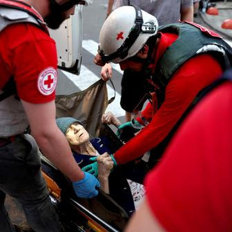 Medical workers evacuate an elderly woman following overnight Russian missile and drone strikes, in Kyiv