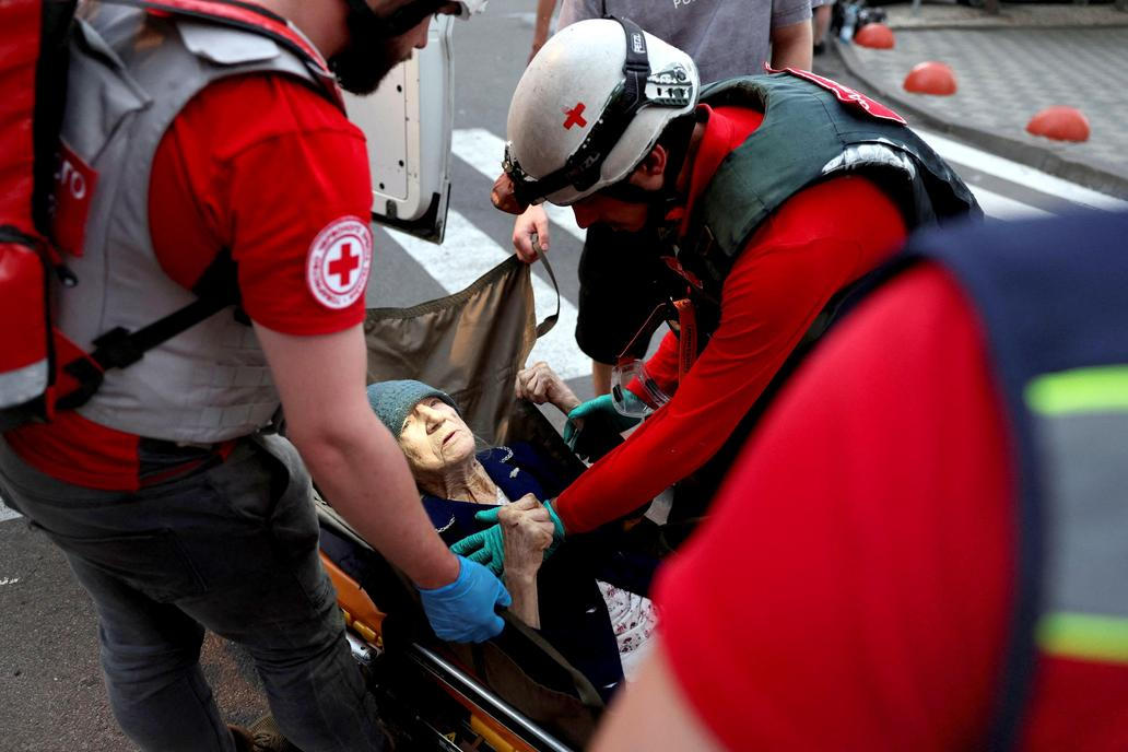 Medical workers evacuate an elderly woman following overnight Russian missile and drone strikes, in Kyiv