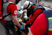 Medical workers evacuate an elderly woman following overnight Russian missile and drone strikes, in Kyiv