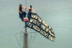 Two people display a banner atop the Empire State Building in the Manhattan borough of New York