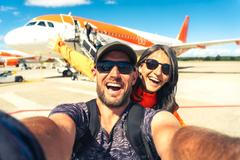 Cheerful,Caucasian,Couple,Taking,Selfie,In,Front,Of,Passenger,Airplane