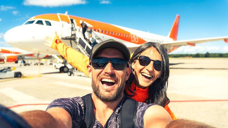Cheerful,Caucasian,Couple,Taking,Selfie,In,Front,Of,Passenger,Airplane
