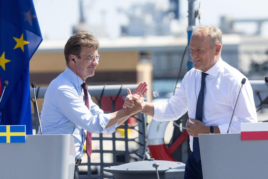 Švédský premiér Ulf Kristersson a polský premiér Donald Tusk se drží za ruce po slavnostním podpisu dohody o koupi tří švédských ponorek třídy A26 Blekinge pro Polsko.