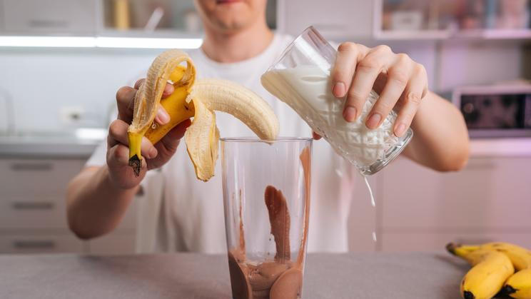 Man,Adding,Milk,And,Peeled,Banana,To,Blender,With,Chocolate