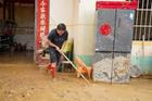 Resident clears mud from a flood-hit home in Hengzhou