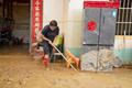 Resident clears mud from a flood-hit home in Hengzhou