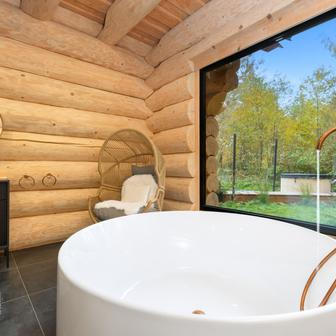 I zde jsou černé akcenty, nyní v podobě baterie u volně stojící vany a výrazného stříbřitého umyvadla na masivní desce. 