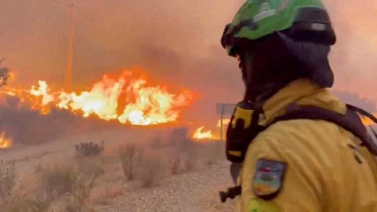An emergency worker looks on during a wildfire in Almeria