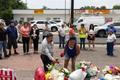 Juan Coronado and Gina Danielsen look through a memorial near the scene of the fatal shooting of Mexican motorist Lorenzo Salgado Araujo