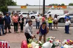 Juan Coronado and Gina Danielsen look through a memorial near the scene of the fatal shooting of Mexican motorist Lorenzo Salgado Araujo