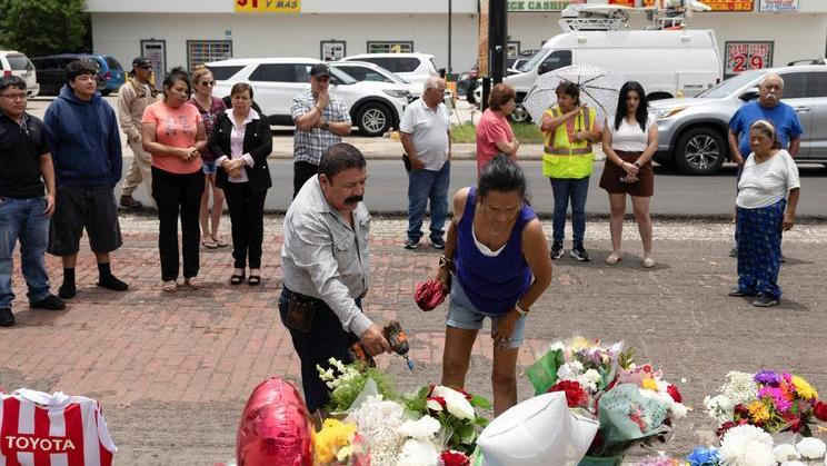 Juan Coronado and Gina Danielsen look through a memorial near the scene of the fatal shooting of Mexican motorist Lorenzo Salgado Araujo