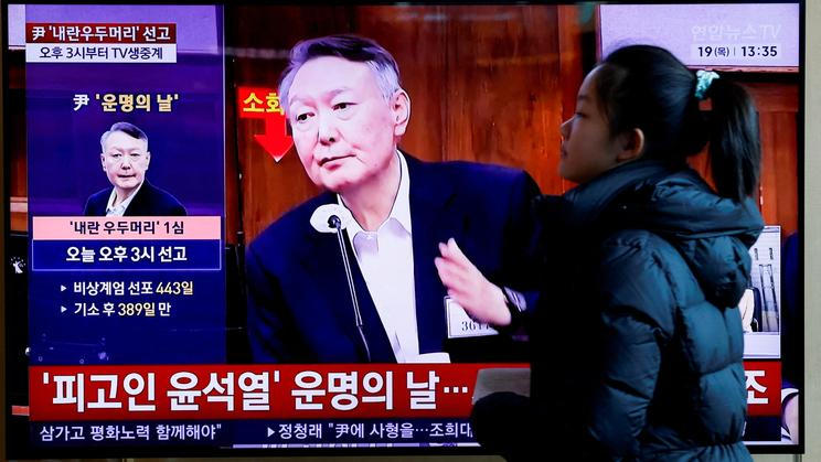 FILE PHOTO: People watch a news report on the sentencing trial of South Korean former president Yoon Suk Yeol's insurrection case in Seoul