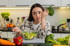 Young,Woman,Eats,Vegetable,Salad,And,Looks,Drained,After,Strict