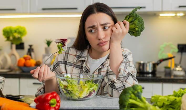 Young,Woman,Eats,Vegetable,Salad,And,Looks,Drained,After,Strict