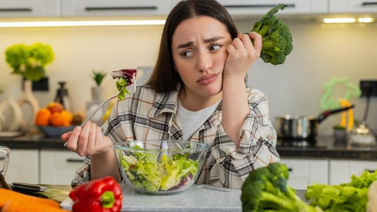 Young,Woman,Eats,Vegetable,Salad,And,Looks,Drained,After,Strict