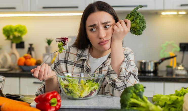 Young,Woman,Eats,Vegetable,Salad,And,Looks,Drained,After,Strict