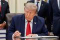 U.S. President Donald Trump signs an executive order in the Oval Office at the White House in Washington