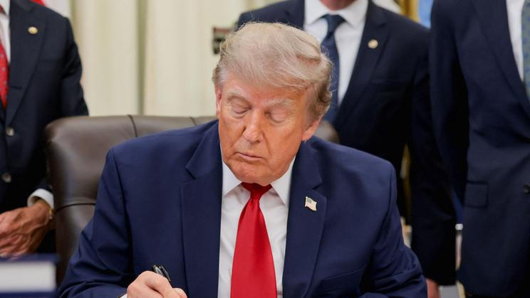 U.S. President Donald Trump signs an executive order in the Oval Office at the White House in Washington