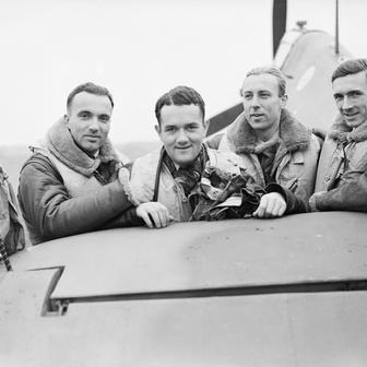 Skupina pilotů polské 303. stíhací perutě RAF stojí u výškového kormidla jednoho ze svých letounů Hawker Hurricane Mk. I na základně Northolt v Middlesexu. Zleva doprava: poručík Mirosław Ferić, nadporučík Bogdan Grzeszczak, poručík Jan Zumbach, nadporučík Zdzisław Henneberg a kapitán John Kent, který v té době velel letce „A“ této perutě.