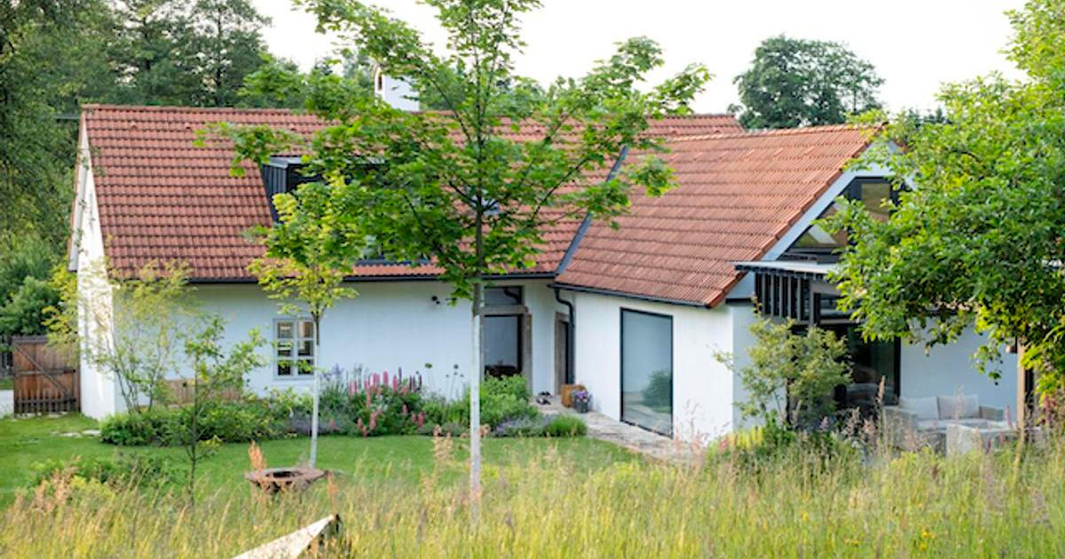 Vlak projíždí za plotem a mezi stromy se skrývá trucovna. Zahrada u chalupy v České Kanadě nepodléhá trendům