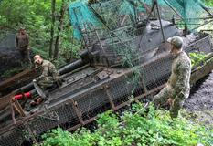 Ukrainian servicemen work with a self-propelled howitzer near a frontline in Donetsk region
