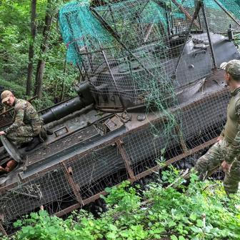 Ukrainian servicemen work with a self-propelled howitzer near a frontline in Donetsk region