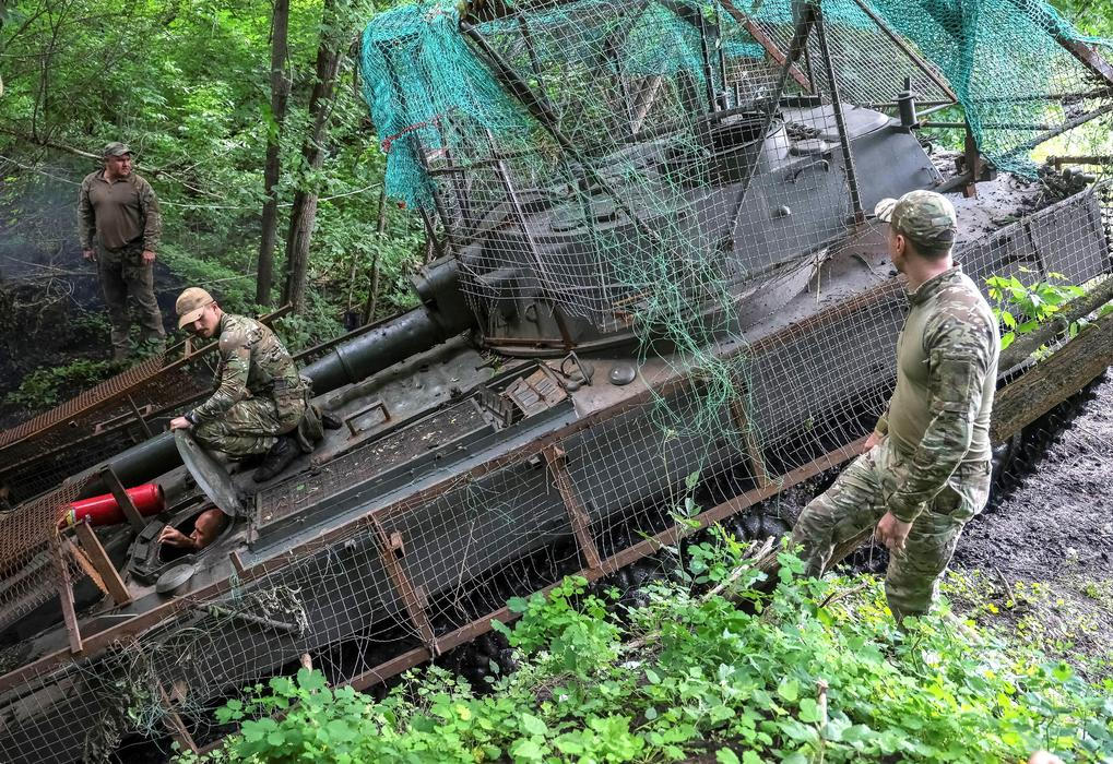 Ukrainian servicemen work with a self-propelled howitzer near a frontline in Donetsk region