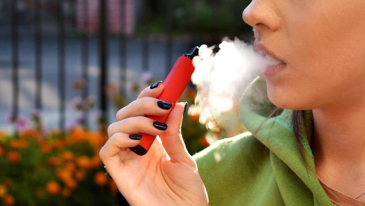 Beautiful,Women,Smoke,Electronic,Cigarette,In,Street