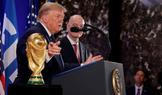 Donald Trump a Gianni Infantino stojí vedle trofeje pro mistry světa ve fotbale během recepce FIFA v newyorské Trump Tower