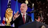 Gianni Infantino stojí vedle trofeje pro mistry světa ve fotbale během recepce FIFA v newyorské Trump Tower