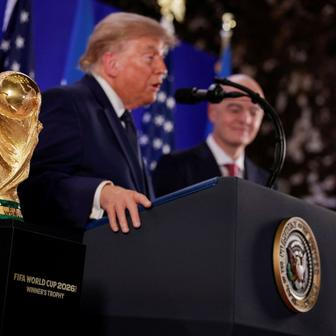 Donald Trump a Gianni Infantino stojí vedle trofeje pro mistry světa ve fotbale během recepce FIFA v newyorské Trump Tower