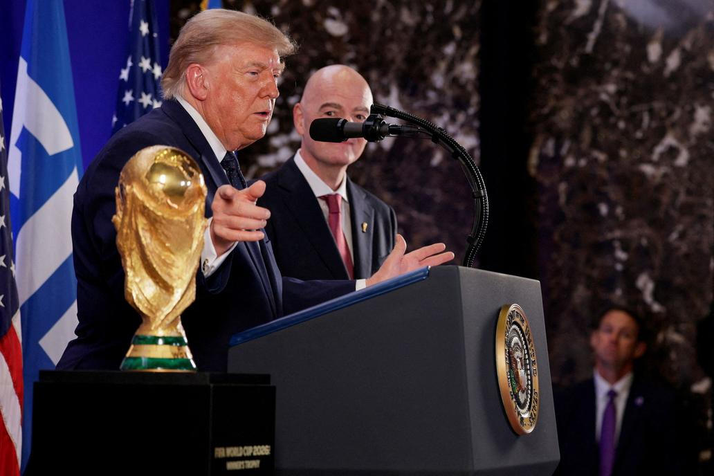 Donald Trump a Gianni Infantino stojí vedle trofeje pro mistry světa ve fotbale během recepce FIFA v newyorské Trump Tower