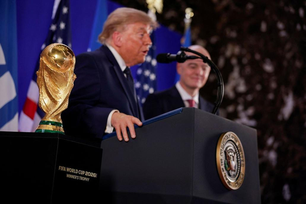 Donald Trump a Gianni Infantino stojí vedle trofeje pro mistry světa ve fotbale během recepce FIFA v newyorské Trump Tower