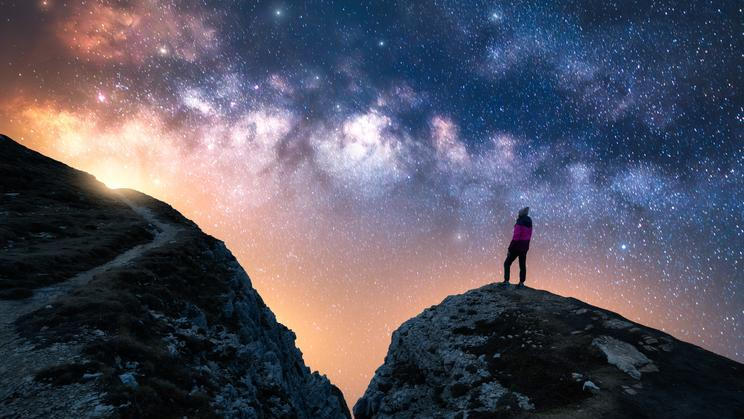 Glowing,Milky,Way,And,Woman,On,Mountain,Peak,At,Starry
