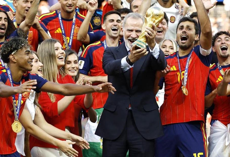 Španělský král Filip VI. slaví s fotbalisty zisk titulu mistrů světa a společně s nimi zvedá nad hlavu slavnou trofej.