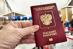 A,Hand,Holds,A,Russian,Passport,In,Line,At,Customs,