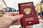 A,Hand,Holds,A,Russian,Passport,In,Line,At,Customs,
