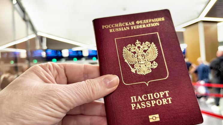 A,Hand,Holds,A,Russian,Passport,In,Line,At,Customs,