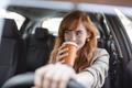 Happy,Young,Woman,With,Coffee,To,Go,Driving,Her,Car.