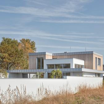 Výrazným prvkem architektury domu je horizontální deska s přesahem kolem celého obvodu. Tvoří zádveří, krytou terasu směrem do zahrady a podporuje charakter stavby.