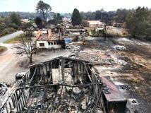 A drone view shows burnt building in an area affected by wildfire, in Le Porge